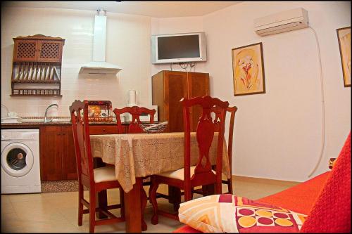 uma cozinha com uma mesa, 2 cadeiras e um micro-ondas em Apartamento Pascual Junquera I em Conil de la Frontera
