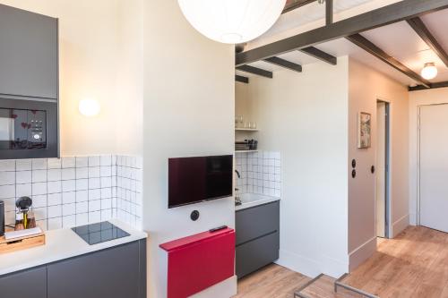 a kitchen with white walls and a red cabinet at Maison Delage in Courbevoie