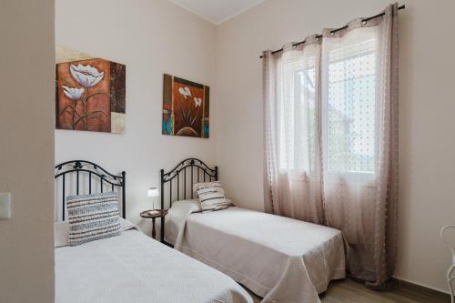 a bedroom with two beds and a window at Casa Viola in Menfi