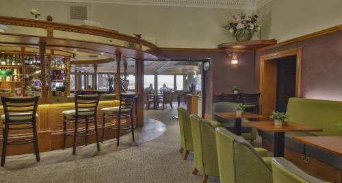 a restaurant with chairs and tables and a bar at Invercarse Hotel Dundee, BW Signature Collection in Dundee