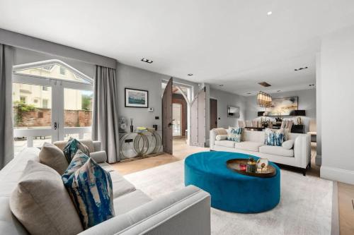 a living room with a couch and a blue table at Luxurious Bowdon Mansion by City SuperHost in Bowdon