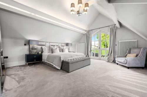a white bedroom with a bed and a chair at Luxurious Bowdon Mansion by City SuperHost in Bowdon