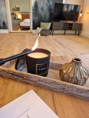 a candle and a vase on a tray in a room at 3 Zimmer Ferienwohnung Harter Brocken in Sankt Andreasberg