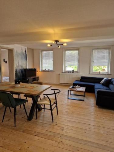 a living room with a table and a couch at 3 Zimmer Ferienwohnung Harter Brocken in Sankt Andreasberg