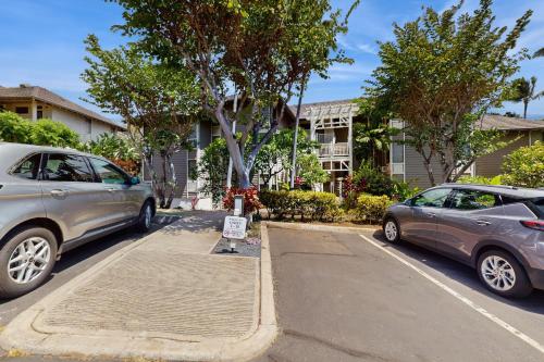 two cars parked on a street in front of a house at Wailea Grand Champions 7 in Wailea