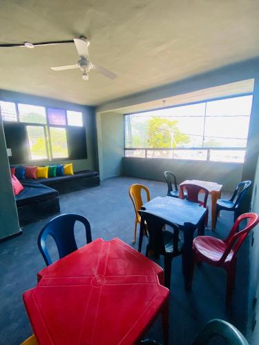 a room with tables and chairs and a couch at Hostel do Meio in Salvador