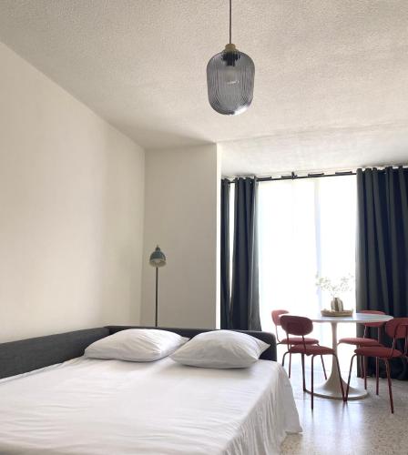 une chambre avec un lit, une table et des chaises dans l'établissement Studio Cosy, à La Grande Motte