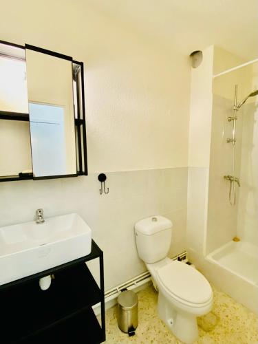 une salle de bains avec toilettes, lavabo et miroir dans l'établissement Studio Cosy, à La Grande Motte
