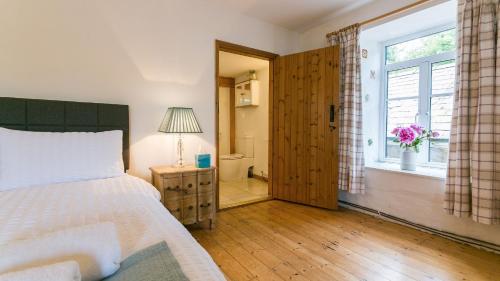 a bedroom with a bed and a window at Felin Hen in Menai Bridge