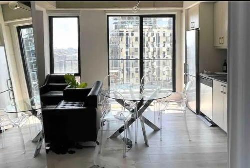 a living room with a glass table and chairs at Loft moderne au coeur de Montreal in Montréal