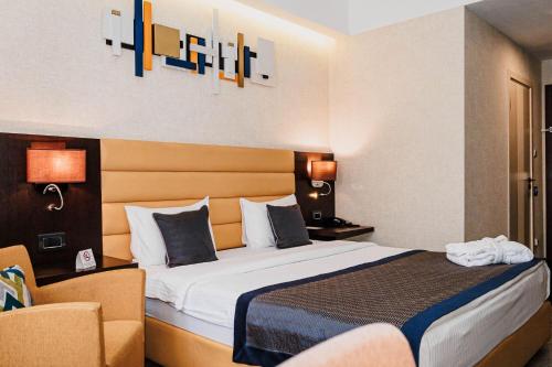 a hotel room with a bed and a chair at Comfort Hotel Astana in Astana