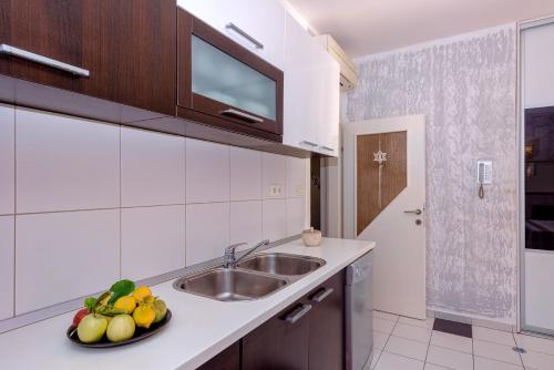 una cocina con fregadero y un bol de fruta en Sunshine, en Hvar