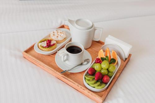 a tray of food with a cup of coffee and fruit at Comfort Hotel Astana in Astana