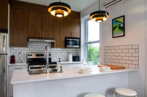 a kitchen with a sink and a stove top oven at Appartement cozy et lumineux avec parking in Montréal