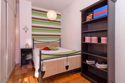 Dormitorio pequeño con litera y pared a rayas en Sunshine, en Hvar