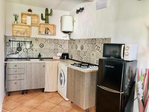 a kitchen with a black refrigerator and a microwave at Finca Abril 1 Piscina Compartida in Conil de la Frontera