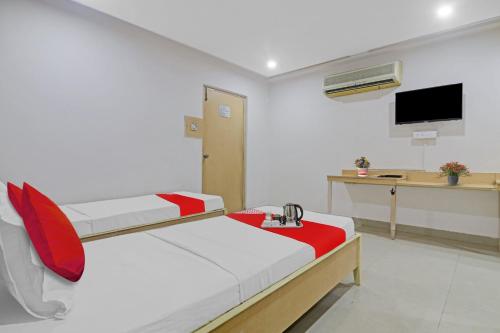 a room with a bed and a desk with a tv at Hotel O Padmini Near Lakdikapool Metro Station in Hyderabad