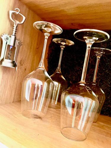 three wine glasses sitting on top of a table at LA MAISON DES BOIS D'OCRE - Gîte Appart Design - Clim Pkg Wifi Jardin à 10mn de Dijon in Messigny-et-Vantoux