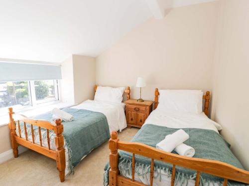 a bedroom with two beds and a window at Bryn Hyfryd in Conwy
