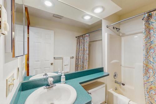 Un baño con lavabo, inodoro y espejo. en Northridge 410, en Tannersville