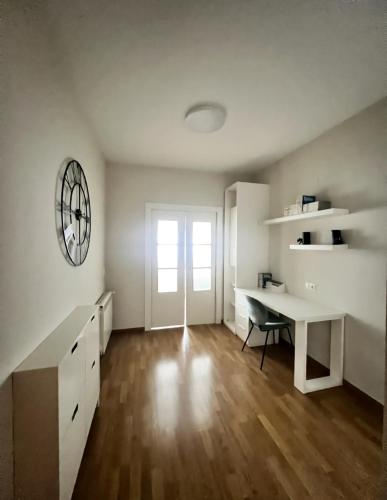 a white room with a desk and a table at Apartamento cerca Universidad de Albacete in Albacete
