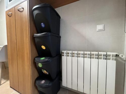 a stack of four black and white containers next to a crib at Apartamento cerca Universidad de Albacete in Albacete