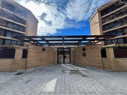 a large brick building with a metal roof over a door at Apartamento cerca Universidad de Albacete in Albacete