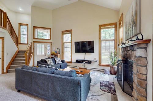 a living room with two couches and a stone fireplace at Northridge 181 in Tannersville