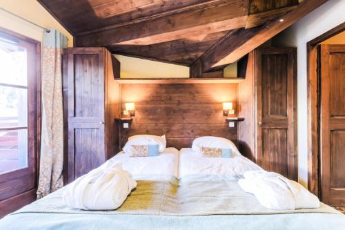 - une chambre avec un grand lit et des murs en bois dans l'établissement Résidence Les Arcs 1950 Le Village - maeva Home - Appartement 2 pièces 4 personnes Sélection MAE-3900, à Bourg-Saint-Maurice