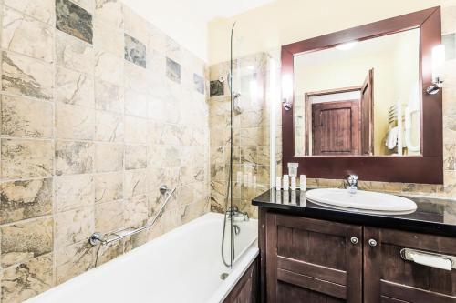une salle de bain avec une baignoire, un lavabo et une douche dans l'établissement Résidence Les Arcs 1950 Le Village - maeva Home - Appartement 2 pièces 4 personnes Sélection MAE-3900, à Bourg-Saint-Maurice