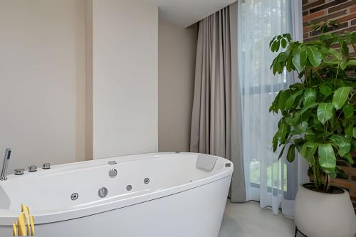 a white bath tub in a bathroom with a plant at Solei Loft 201 - Luxe Stay in El Poblado in El Poblado