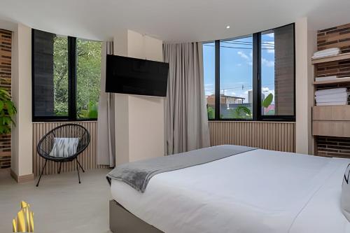 a bedroom with a bed and a flat screen tv at Solei Loft 201 - Luxe Stay in El Poblado in El Poblado