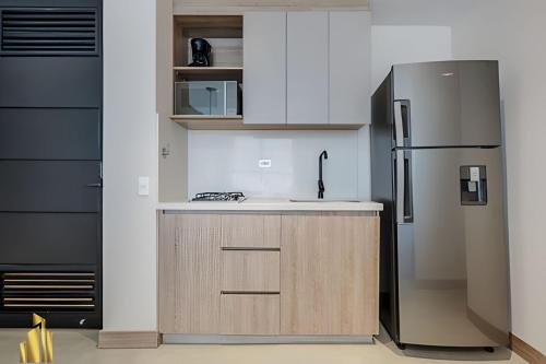 a kitchen with a stainless steel refrigerator and cabinets at Solei Loft 201 - Luxe Stay in El Poblado in El Poblado