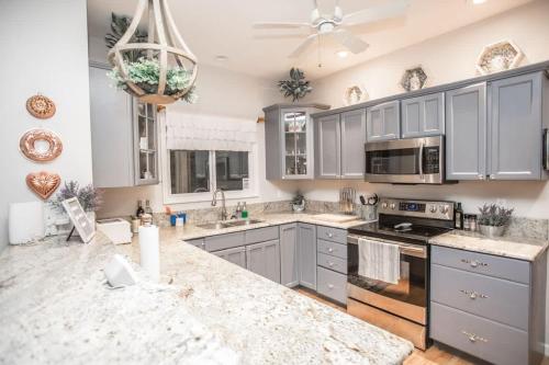 Una cocina con gabinetes grises y encimera de mármol. en Apple Valley Chateau Mountain Getaway, en Hendersonville