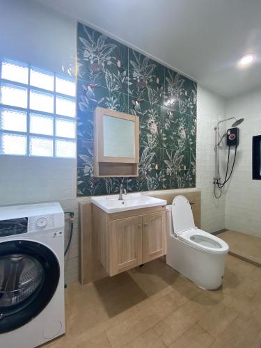 a bathroom with a washing machine and a toilet at Morgen Resort24h in Ban Don