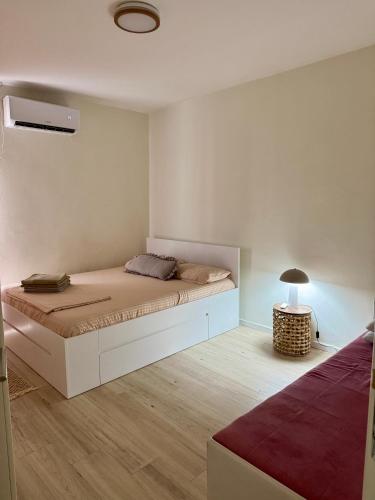 a bedroom with a large bed and a lamp at Central Prestige Apartment in Budva
