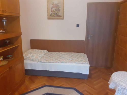 バラトンボグラールにあるApartment in Balatonboglar - Balaton 18183のベッドと木の床のある小さな寝室