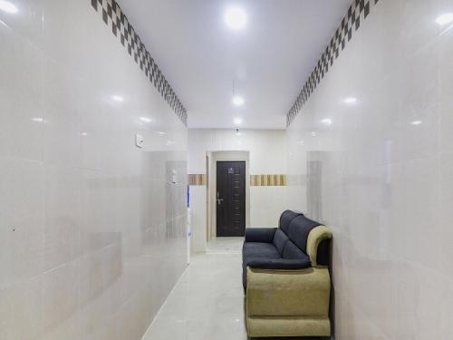a hallway with a blue couch in a room at Hotel O Aroma Classic Near Nampally Railway station in Hyderabad