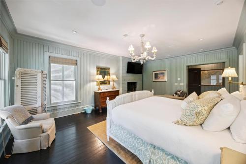 a bedroom with a large white bed and a chair at AV9-02: 9 2nd Avenue in Isle of Palms