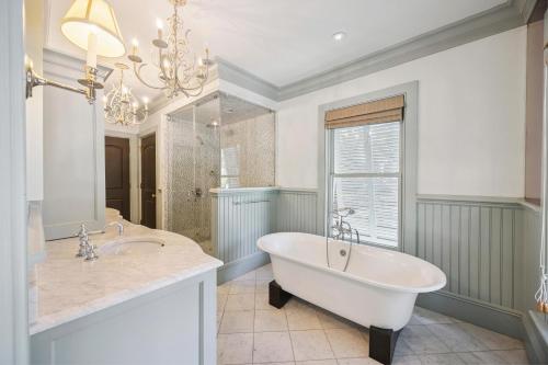 a bathroom with a tub and two sinks and a chandelier at AV9-02: 9 2nd Avenue in Isle of Palms
