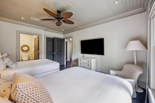 a bedroom with two beds and a flat screen tv at AV9-02: 9 2nd Avenue in Isle of Palms