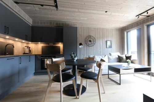 a kitchen and living room with a table and a couch at Stylish apartment in Hemsedal, Ski in-ski out in Hemsedal