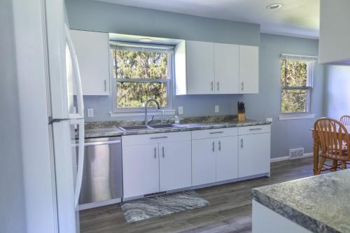 a kitchen with white cabinets and a white refrigerator at Fisher's Fancy l Near the river & in house games in Berrien Springs