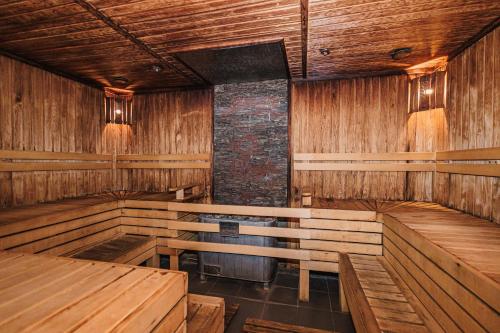 an empty room with wooden tables and benches at Comfort Hotel Astana in Astana