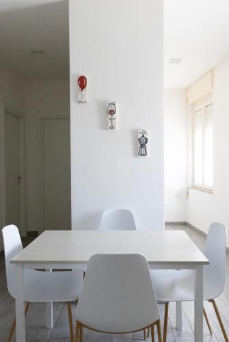 a white dining room with a white table and chairs at Bilocale Vega-Intero appartamento ad uso esclusivo by Appartamenti Petrucci by Appartamenti Petrucci in Foligno
