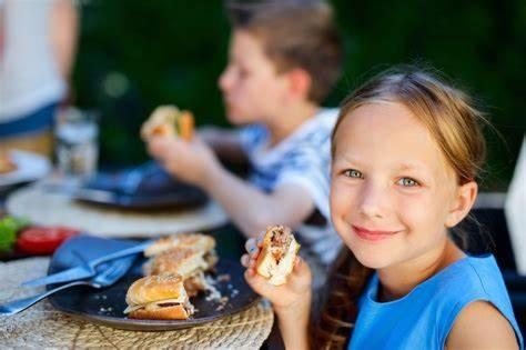 a little girl sitting at a table with a plate of food at Hermosa Haven home in Montrose