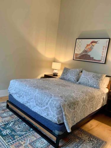 a bedroom with a bed and a lamp and a rug at Historic Arts District Gastro Loft in Benton Harbor