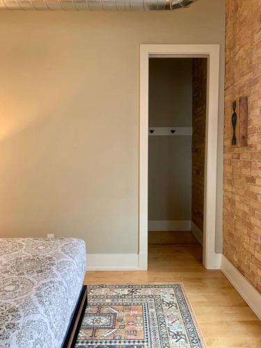a bedroom with a bed and a brick wall at Historic Arts District Gastro Loft in Benton Harbor