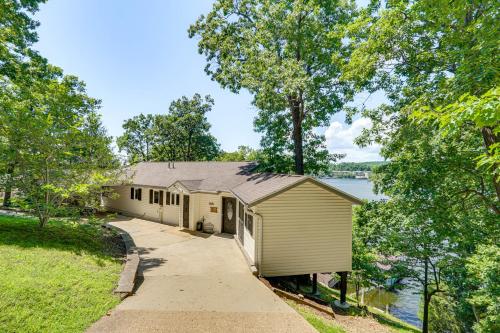 a building with a sidewalk next to a body of water at Hot Tub and Dock Lake Ozark Vacation Home! in Lake Ozark