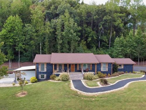 a house with a gambrel roof and a driveway at Southern Comfort Retreat with a private hot tub in Scottsboro